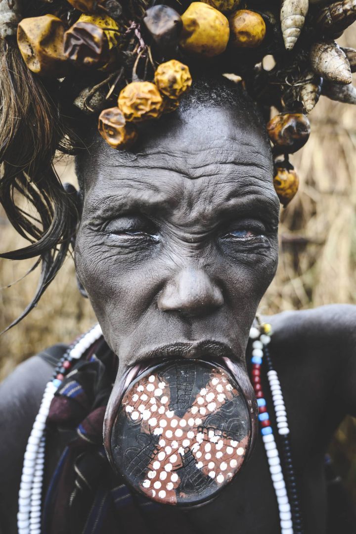 fotografía artística de retrato de un hombre de la tribu Mursi con plato en labio dilatado