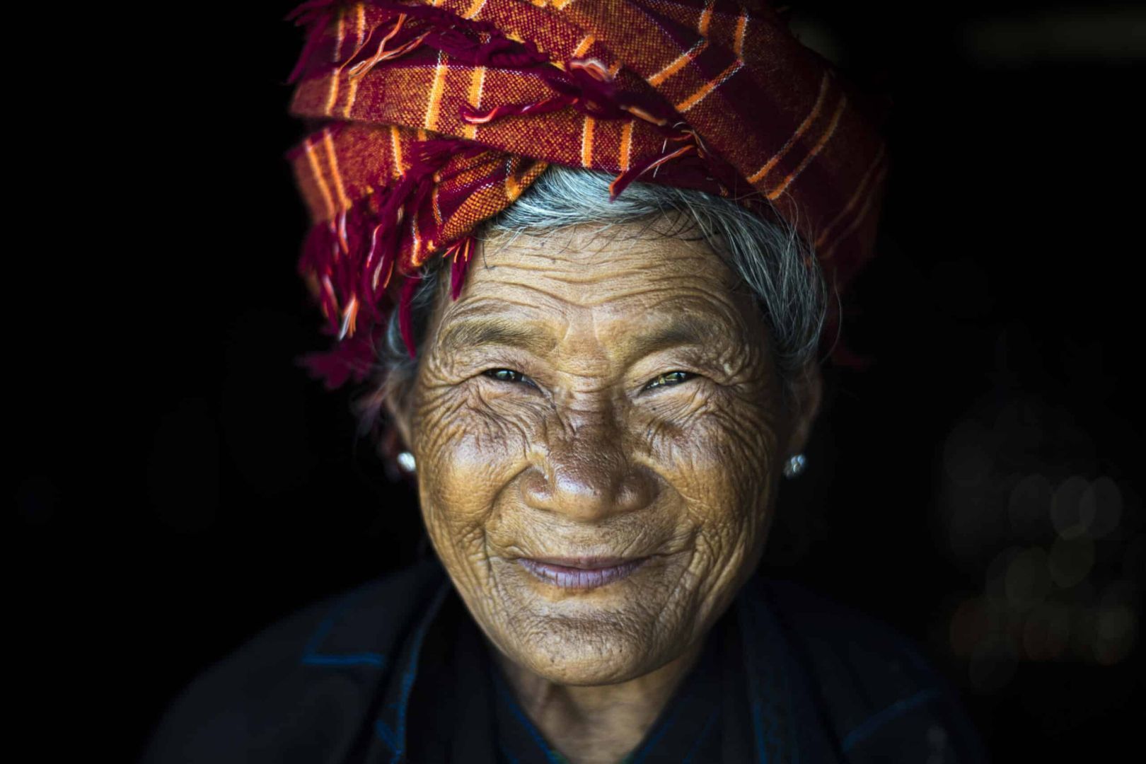 fotografía artística de retrato de una mujer anciana con sonrisa de felicidad en birmania